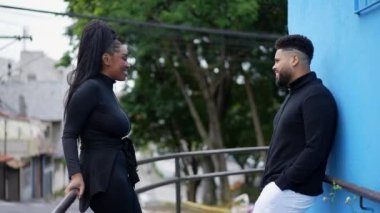 Kadın ve erkek dışarıda gizli gizli sohbet ediyorlar.