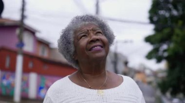 A senior black woman looking up at sky with HOPE
