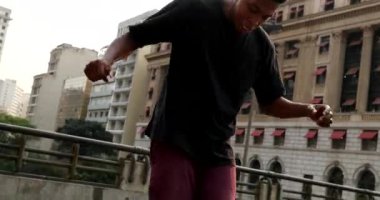 Urban dancers performing outside in city downtown. Black guy dancing