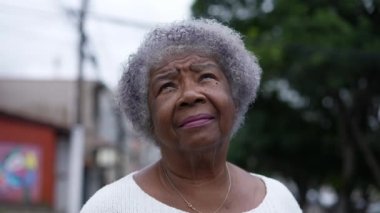 A senior black woman looking up at sky with HOPE
