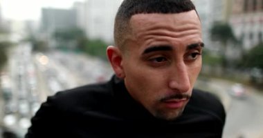 Frustrated lonely young hispanic man in city
