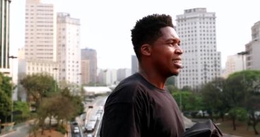 Black man wiping sweat from face with t-shirt