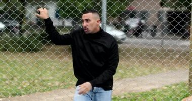 Hispanic guy leaning on metal fence outside. Latino south american person