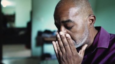 A worried senior person rubbing face with hands feeling hopeless