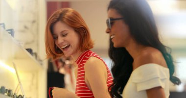 Samimi arkadaşlar güneş gözlüğü alıyor, gülüyor ve gülümsüyor.