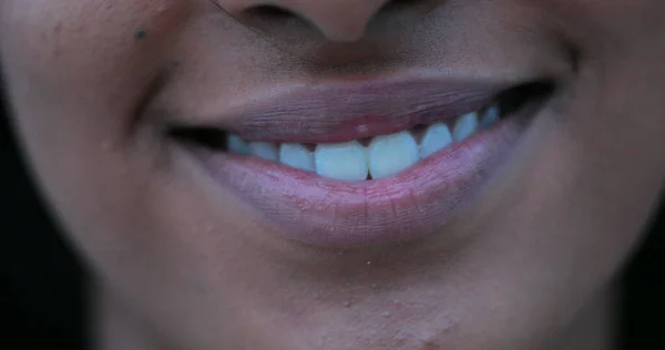 Close-up of woman mouth smiling. African american lips and mouth cracking a smile closeup