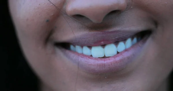 Close-up of woman mouth smiling. African american lips and mouth cracking a smile closeup