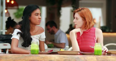 Restoranda yemek yiyen çok ırklı kız arkadaşlar.