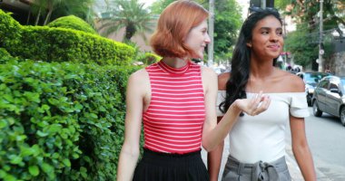 Şehirde yürüyen iki güzel genç kadın.