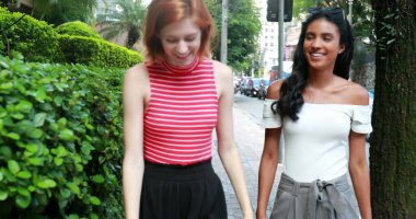 Şehirde yürüyen iki güzel genç kadın.