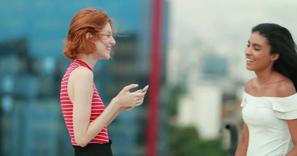 Two friends on top of building wind blowing