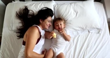 Happy Mother and baby son relationship in morning bed, top view