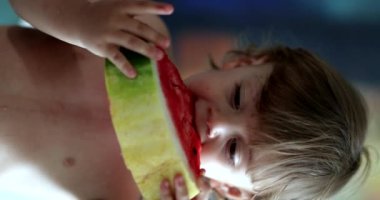 Toddler boy eating watermelon fruit, vertical video