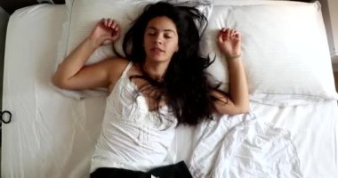 Woman lying in bed resting, top view of girl rests in bed