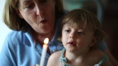 Büyükannem torunumla mum üflüyor. Doğum gününü kutluyor.