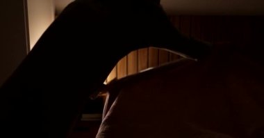 Woman making bed adjusting blanket, wpman tighting up bed