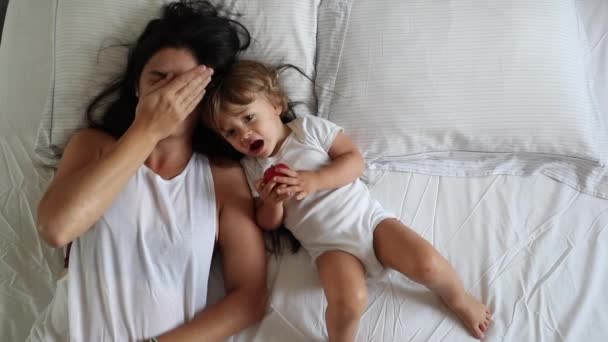 Tired Mother Rubbing Face Lying Bed Toddler Child — Vídeos de Stock