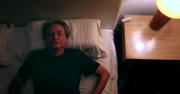 Older Man Lying Bed Night Turning Nightstand Lamp Light Person — Stockvideo