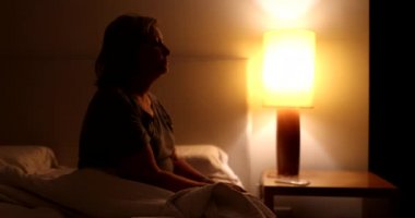 Person getting out of bed at night. Woman gets up at dawn