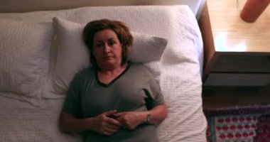 Older woman getting out of bed at night