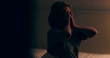 Senior woman getting up from bed at night. Tired person waking up at dawn