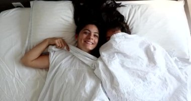 Fun couple under blanket laughing and playing hide and seek peekaboo