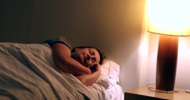 Person turning nightstand light on. Senior woman waking up in the middle of the night suffering from insomnia