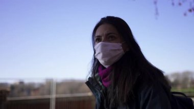 Woman wearing covid-19 face mask walking outside