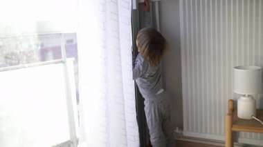 Baby toddler pressing automatic blinds, closing shades