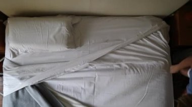 Yatak yapan kişi, üst dikey görünüm, ev işi.