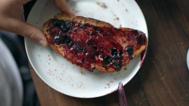 Child eating toast covered with jelly