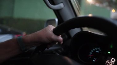 Close-up hands holding steering wheel driving on road