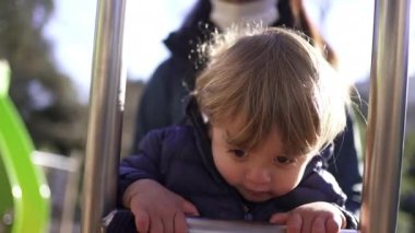 Active Little toddler boy climbing playground staircase outside in sunlight