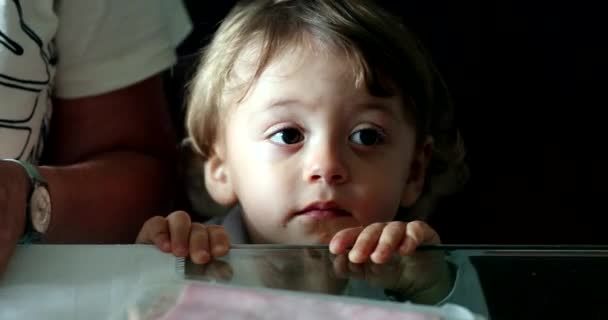 Милий Малюк Хлопчик Спирається Скляний Стіл Підгляданням Рук Дивиться Камеру — стокове відео