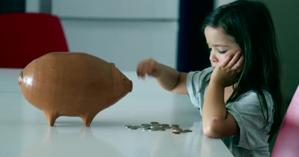Child Adding Coins Piggy Bank — Stock video