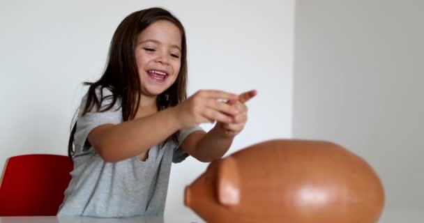Маленька Дівчинка Заощаджує Гроші Додаючи Монети Всередині Скарбнички — стокове відео