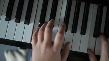 Child hands playing piano close-up