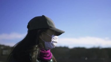 Woman wearing covid-19 face mask walking outside
