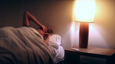 Woman turning bedside lamp off. Senior turns light bulb off