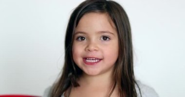 Happy little girl smiling at camera. Cute adorable child portrait face