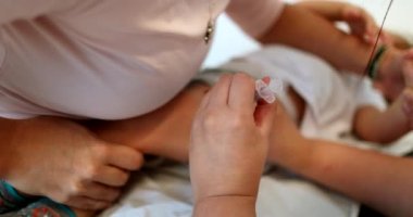 Vaccinating baby toddler. Parent holding infant for vaccination
