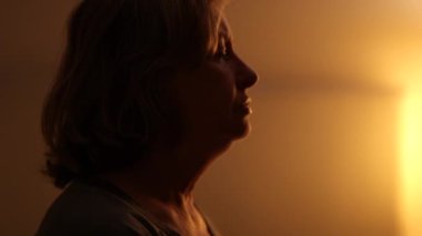 Worried older woman stressed in preoccupation at night before sleep, senior person taking a deep breath