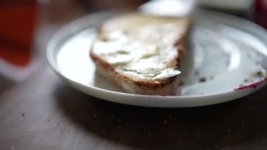 Close-up person spreading jelly on bread with butter