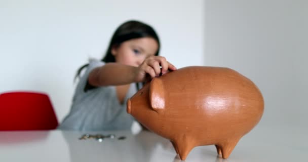 Маленька Дівчинка Заощаджує Гроші Додаючи Монети Всередині Скарбнички — стокове відео