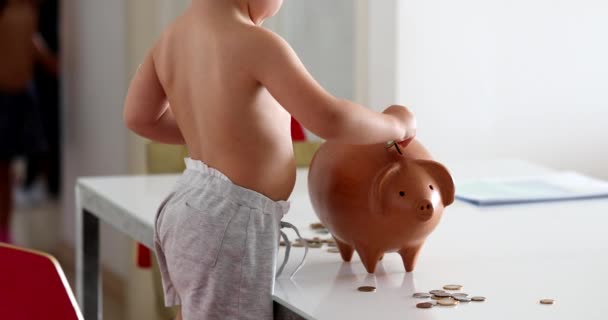 Adorable Baby Boy Adding Savings Piggy Bank — Vídeo de Stock