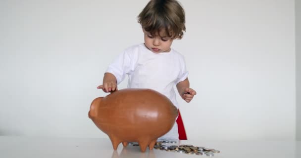 Маленький Хлопчик Заощаджує Гроші Кладе Монети Всередину Скарбнички — стокове відео