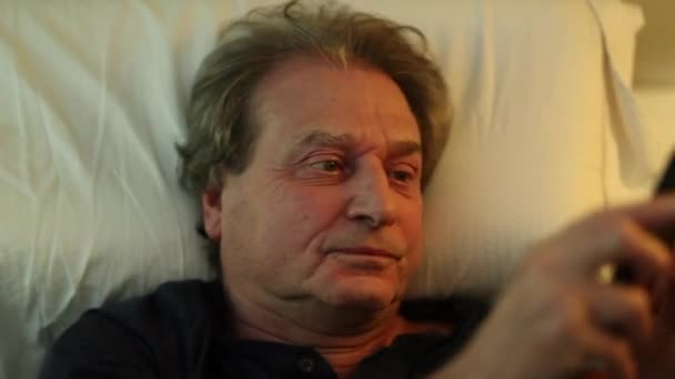 Older Man Lying Bed Using Cellphone Device — 图库视频影像