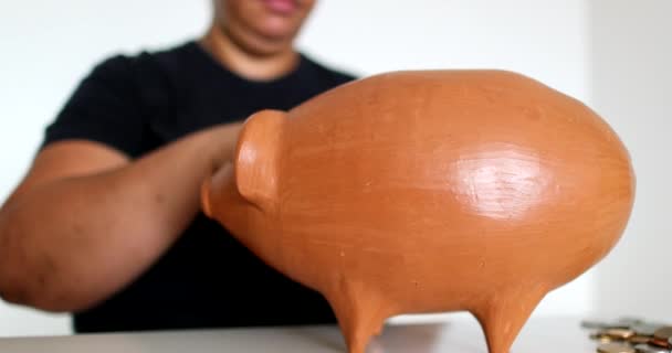 Close Black Person Hands Putting Coins Piggy Bank — Αρχείο Βίντεο