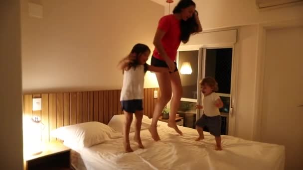 Mutter Springt Mit Kindern Aufs Bett — Stockvideo