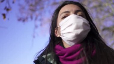 Woman wearing covid-19 face mask walking outside